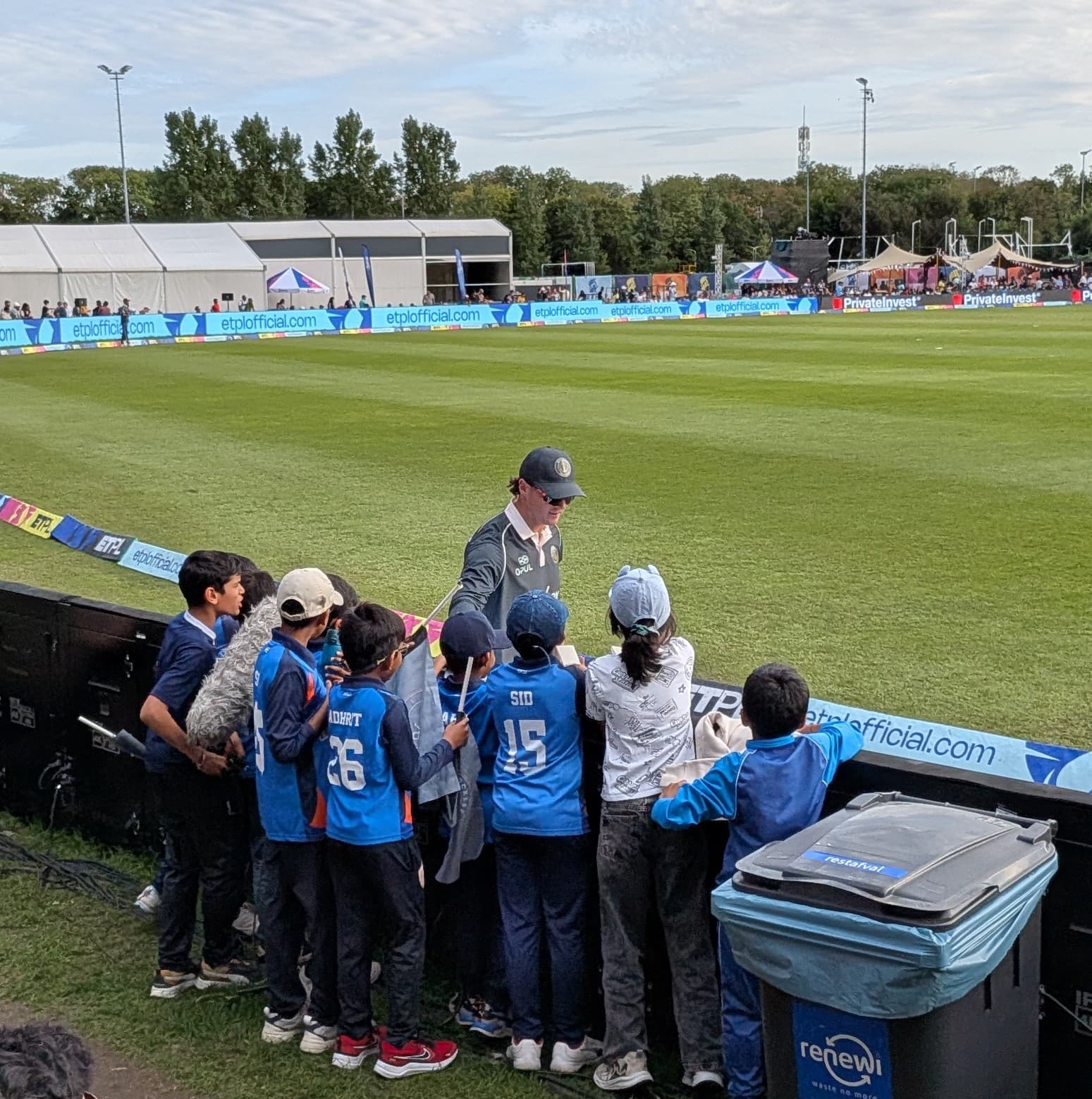 Young ECC fans meeting a cricket player beside the boundary at a cricket event