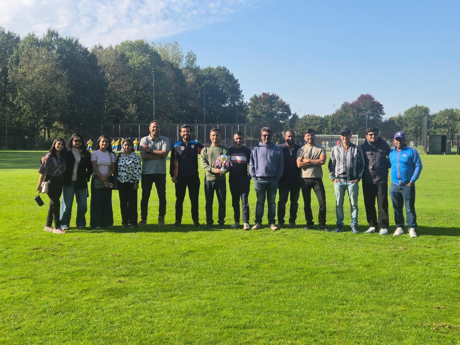 ECC parents and club supporters together on the cricket ground with a trophy