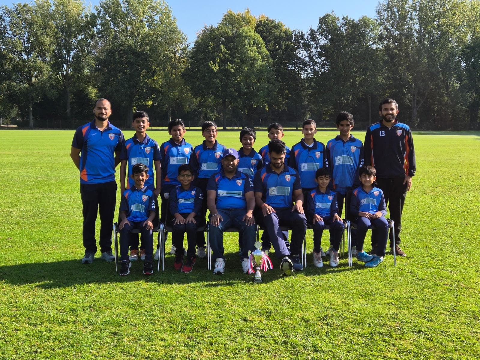 The ECC youth cricket team and their coaches together on the club ground
